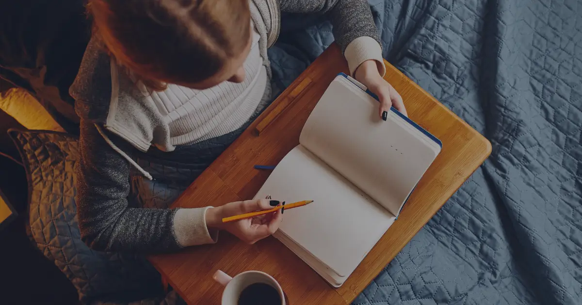 a woman writing in a notebook about introvert journaling methods